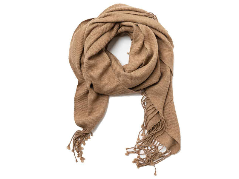Handwoven alpaca scarf in a soft camel tone with twisted fringe ends, shown looped and draped against a clean white background.